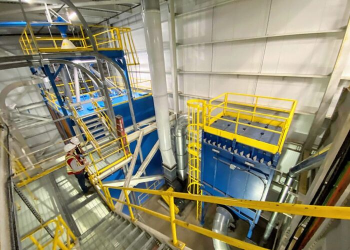 Employees overlooking part of the bean cleaning system. Entire bean cleaning system
