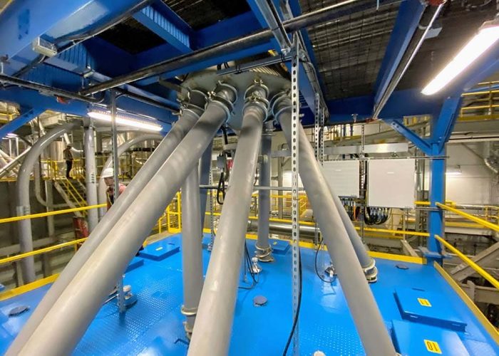 Rotary distributor feeding mass flow silos for decaffeinated green bean blends.